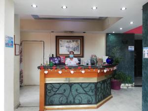 a man wearing a mask at a counter in a room at Hotel Tamazunchale in Tamazunchale