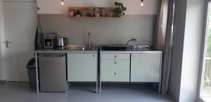 a kitchen with white cabinets and a sink at Anno 1874 in Leens
