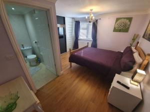 1 dormitorio con cama morada y baño en Sherwood Bungalow 3 Bedroom Entire Property, en Boston