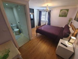 a bedroom with a purple bed and a bathroom at Sherwood Bungalow 3 Bedroom Entire Property in Boston