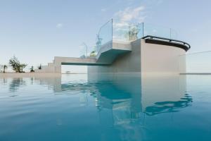 a house with a pool of water at Three House Hotel in Funchal
