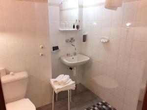 a white bathroom with a toilet and a sink at Hotel Casanova in Duchcov