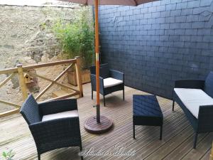 a patio with chairs and an umbrella on a deck at La Venelle du Bassin in Honfleur