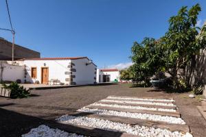 El AlbercónCasa con encanto的房屋前有石头走道的院子