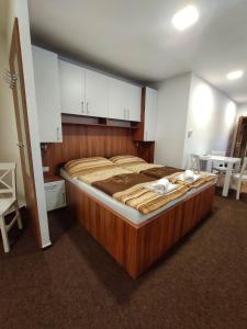 a large wooden bed in a room with white cabinets at Penzion Svatý Jan in Turnov