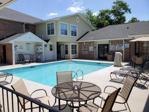 a swimming pool with tables and chairs next to a house at Quality Inn & Suites in Lexington