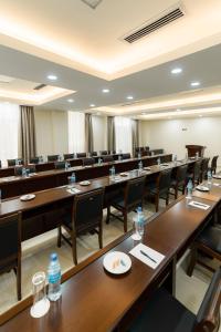 Kibo Palace Hotel Moshi في موشي: غرفة كبيرة مع صفوف من الطاولات والكراسي