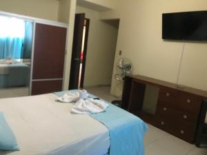Hotel Viru Viru II في سانتا كروز دي لا سيرا: غرفة نوم عليها سرير وفوط