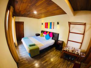 a bedroom with a large bed and a chair at Pigeons Nest in Nuwara Eliya