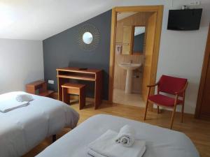 a bedroom with a bed and a desk and a sink at La Gallega in Cacabelos