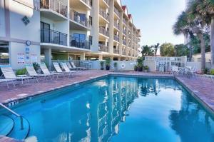 a swimming pool in front of a hotel at Vistas on the Gulf by Travel Resort Services in St Pete Beach
