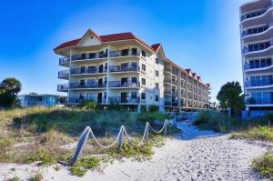 a building on the beach next to a beach at Vistas on the Gulf by Travel Resort Services in St Pete Beach