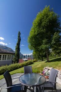 d'une terrasse avec une table, des chaises et un arbre. dans l'établissement Flotunet - Anestova, à Stryn