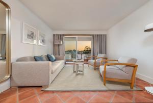a living room with a couch and a table and chairs at The Patio Suite Hotel in Albufeira