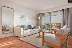 a living room with a couch and a chair at The Patio Suite Hotel in Albufeira