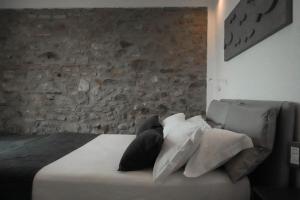 1 dormitorio con pared de piedra y 1 cama con almohadas en Cinque Terre Coast to Coast, en Riomaggiore