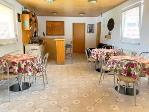 a room with tables and chairs and a kitchen at Apartmaji in sobe Kocjančič in Podčetrtek