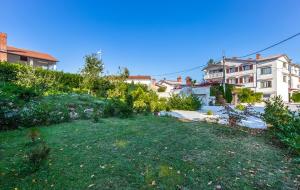a view of a yard with houses in the background at Apartments and Rooms Lago Rupa in Rupa