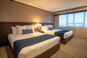 Postel nebo postele na pokoji v ubytování Grand Hotel Tijuana