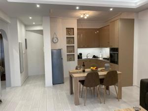 a kitchen with a table and chairs and a refrigerator at Helena's apartment in Volos