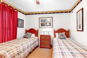 two beds in a bedroom with red curtains at Sea Colony - 55037 Pine Lake in Bethany Beach +30 photos