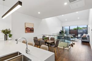 cocina y sala de estar con mesa y sillas en Little Grenfell Apartments by Urban Rest en Rose Park