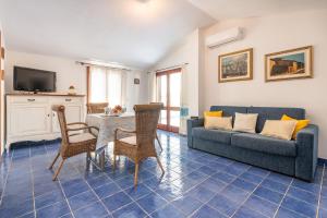 uma sala de estar com um sofá, uma mesa e cadeiras em CASE I GINEPRI A/B E ATTICO em Cala Gonone
