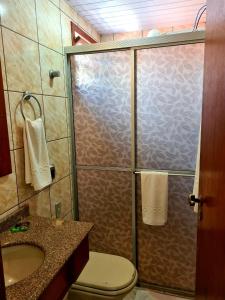 a bathroom with a shower with a toilet and a sink at Bartholo Plaza Hotel Santa Catarina in Penha
