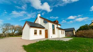 a white house with a driveway at Stylish, Spacious Sea View House in Galway