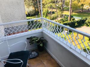 a balcony with a white railing and a plant at Carolina’S Nest in Casal Palocco