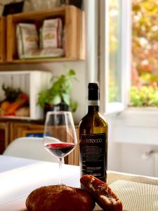 ein Glas Wein neben einer Flasche Wein und Fleisch in der Unterkunft Casa Italia in Verona