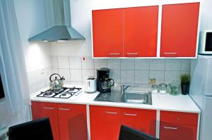 eine kleine Küche mit roten Schränken und einem Waschbecken in der Unterkunft Apartment Rosa 1 (AP-A4) in Rovinj