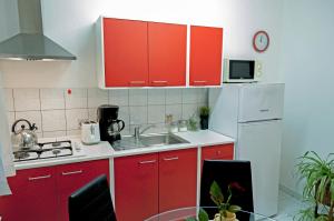 eine Küche mit roten Schränken und einem weißen Kühlschrank in der Unterkunft Apartment Rosa 1 (AP-A4) in Rovinj