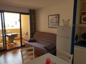 uma pequena sala de estar com um sofá e uma mesa em Les terrasses de Sylvabelle em La Croix-Valmer