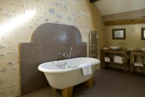 ein Badezimmer mit einer Badewanne und einem Waschbecken in der Unterkunft Coté Parc in Rémalard
