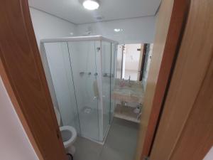 a bathroom with a shower and a toilet and a sink at Apartamento em Torres in Torres +16 photos