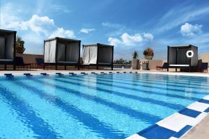 una gran piscina con sillas y un edificio en Grand Hotel Tijuana, en Tijuana