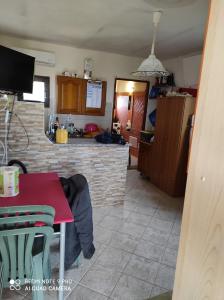 una cucina e una sala da pranzo con tavolo rosso di Studio flat a Golfo Aranci