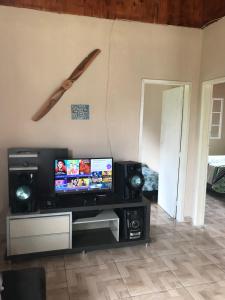 ein Wohnzimmer mit einem TV und einem Baseballschläger an der Wand in der Unterkunft Casa Ibitipoca in Conceição da Ibitipoca