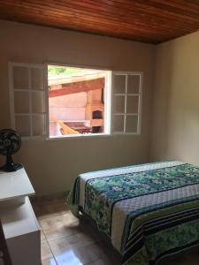 ein Schlafzimmer mit einem Bett und einem Fenster in der Unterkunft Casa Ibitipoca in Conceição da Ibitipoca
