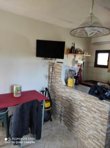 un soggiorno con tavolo rosso e muro di mattoni di Studio flat a Golfo Aranci