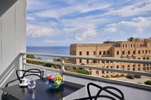 balcone con tavolo, sedie e vista sull'oceano di AQUAMARE CITY and BEACH a Città di Rodi