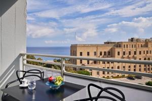 een balkon met een tafel en stoelen en uitzicht op de oceaan bij AQUAMARE CITY and BEACH in Rhodos-stad