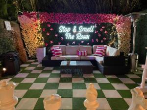 Un escenario con un sofá y un letrero que dice "comprar y oler las rosas" en 4 BR - Sleeps 8! Celebrity Villa Next to Frenchman St, en Nueva Orleans