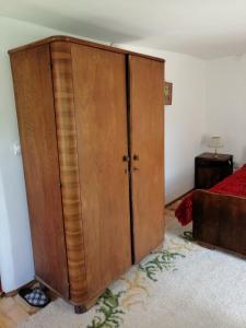 a large wooden cabinet in a room with a bed at Etno kuca Nikolov in Dimitrovgrad