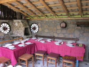 una mesa con mantel rosa y sillas en una habitación en Etno kuca Nikolov, en Dimitrovgrad