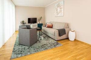 uma sala de estar com um sofá e uma cadeira em Ferienwohnung Pfänder em Friedrichshafen