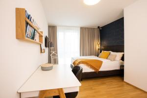 a bedroom with a bed and a table in a room at Ferienwohnung Pfänder in Friedrichshafen