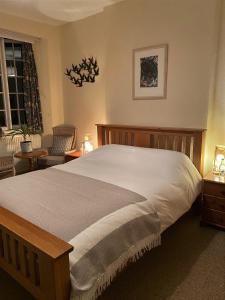 a bedroom with a bed and a chair and a window at The Tors in Okehampton