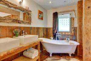 a bathroom with a tub and a sink at La Ferme du Lac Vert in Montriond +70 photos